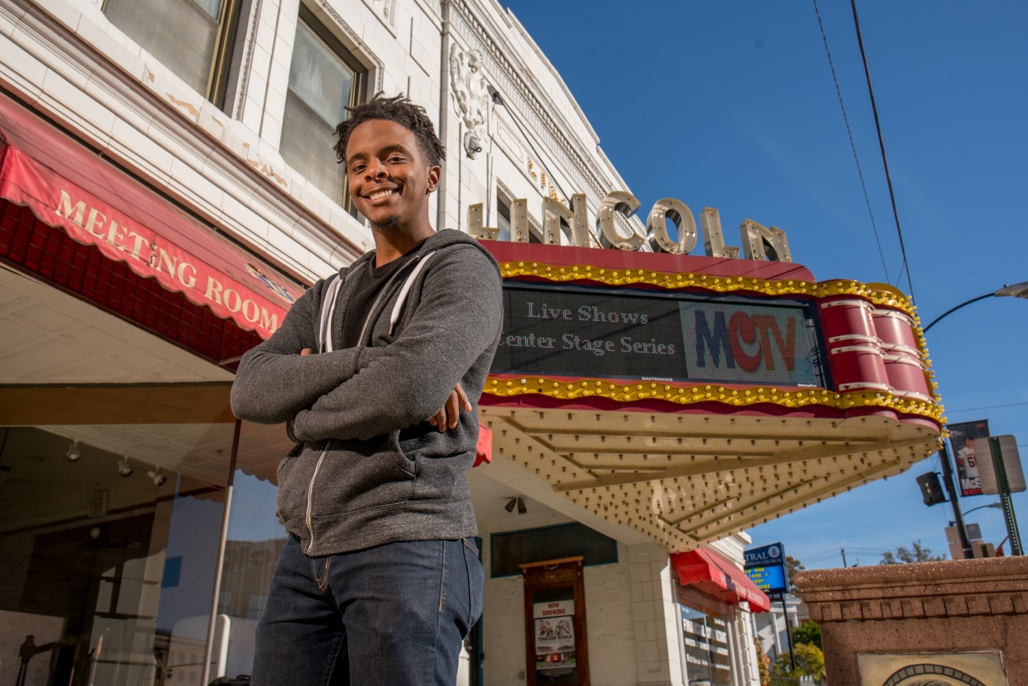 confident teen standing outside a theater