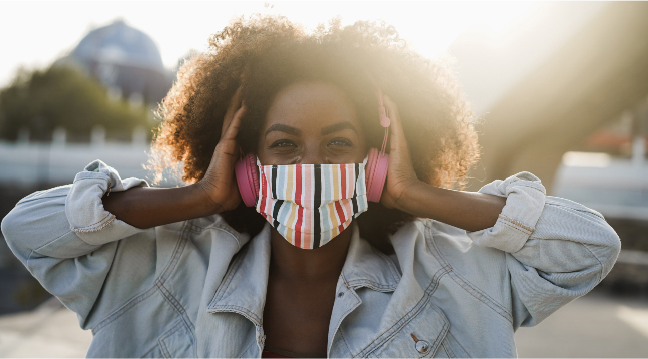 Young woman with a kind smile, wearing a face mask and headphones