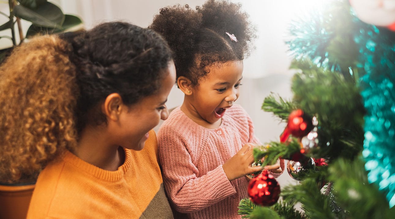 Mother and daughter decorating tree