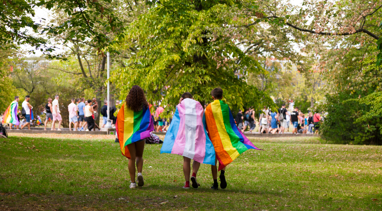 Three people draped in PRIDE flags at one of the PRIDE events in Ohio