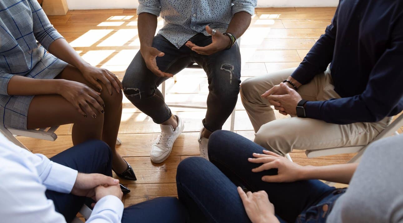 People seated in a circle for addiction counseling